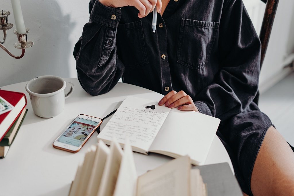 A student girl sitting and writing some notes in her notebook