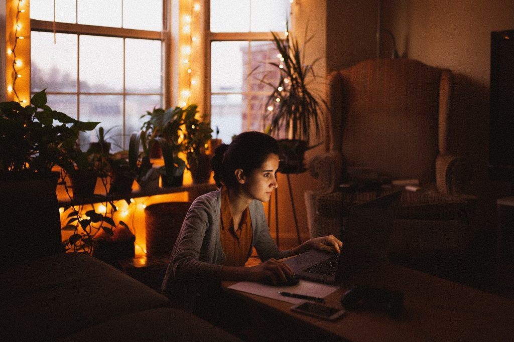 A younr girl student sitting and writing something at the evening