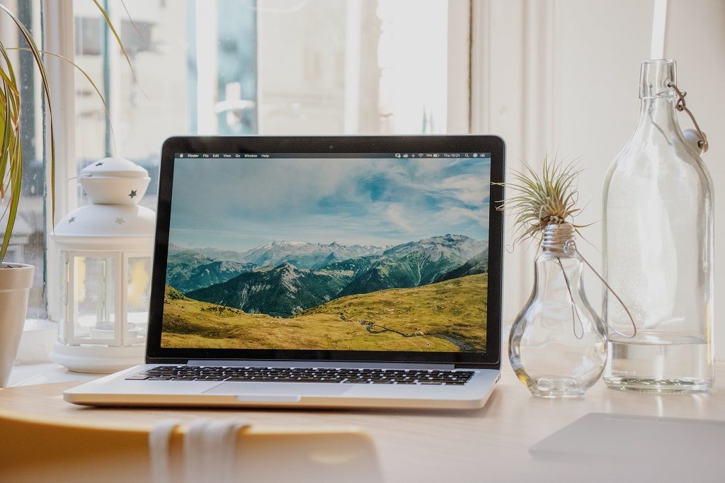 Notebook placed on the table with mountain flat lay on screen