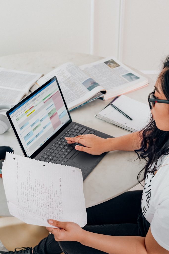 Student girl working on her laptop and making some researchers 