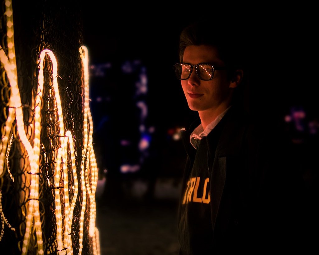 Young men is standing in front of lightning The Meaning of Being Involved. Focus on Important Things