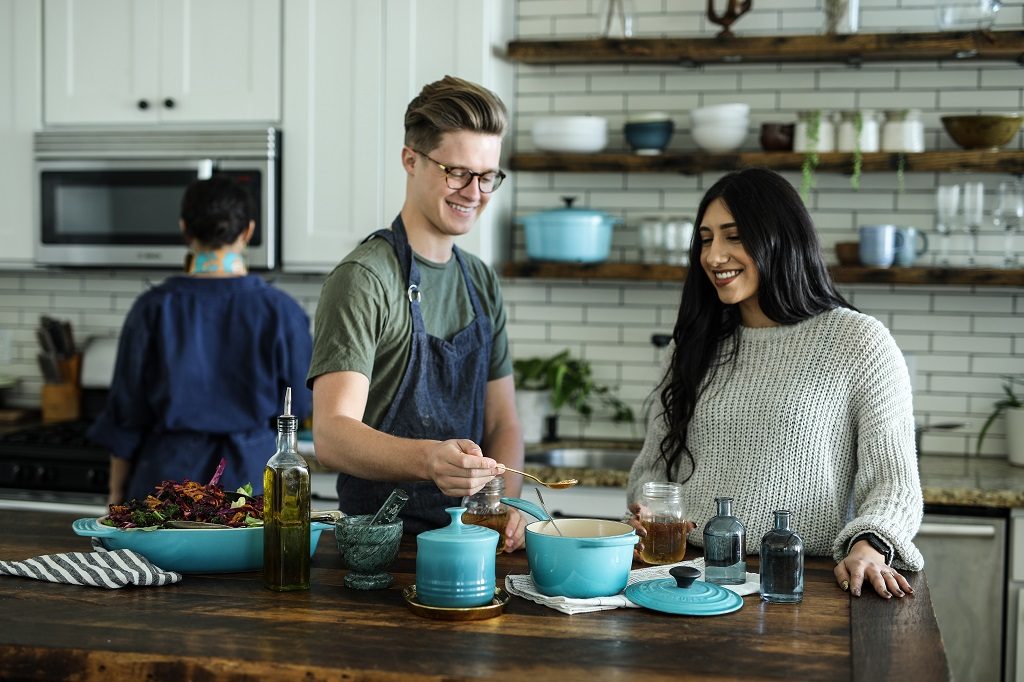 Friends cooking together in the kitchen together.