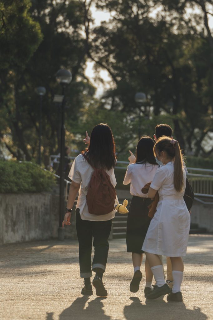 Student girls discussing something in a university yard.